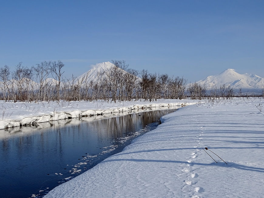 Winter landscape with snow-covered mountains and a frozen river