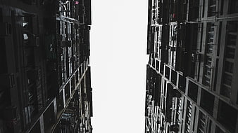 Low angle view of tall apartment buildings with white sky