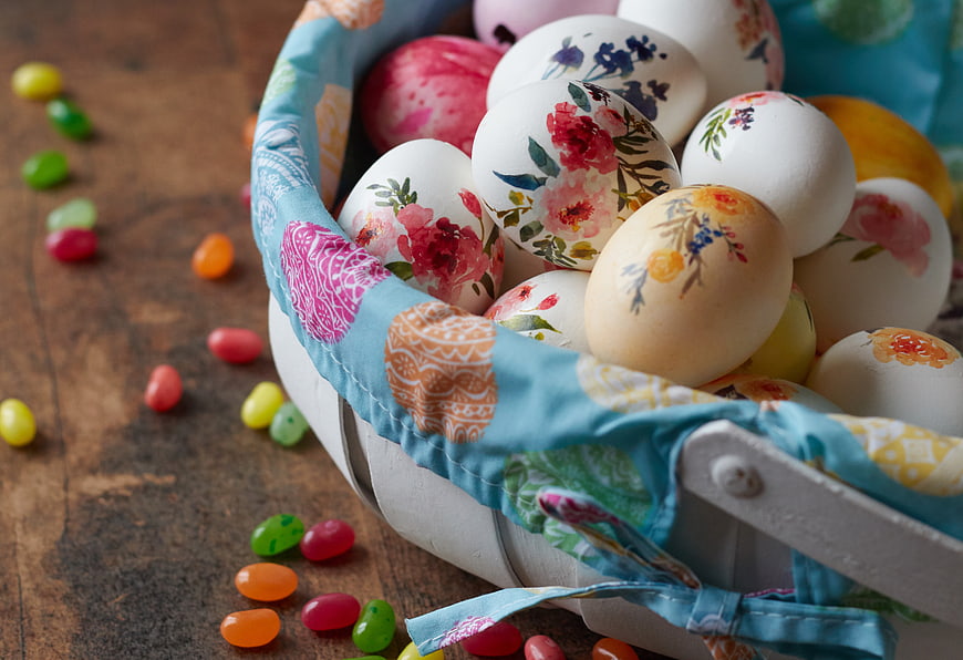 Hand-painted Easter eggs in a basket with jelly beans