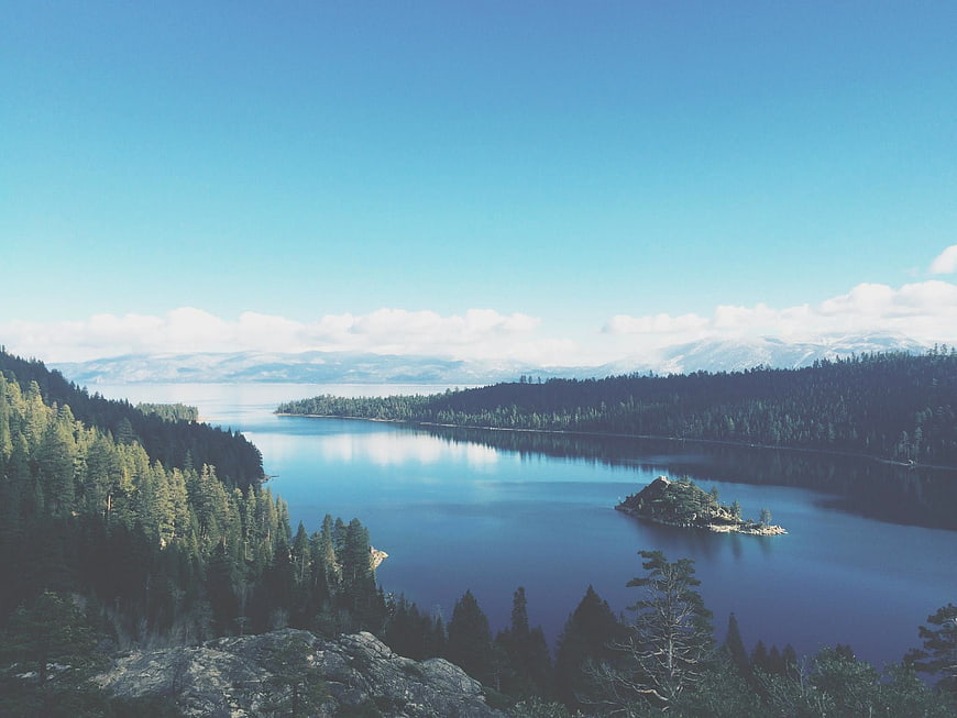 Serene Alpine Lake with Forested Hills and Small Island