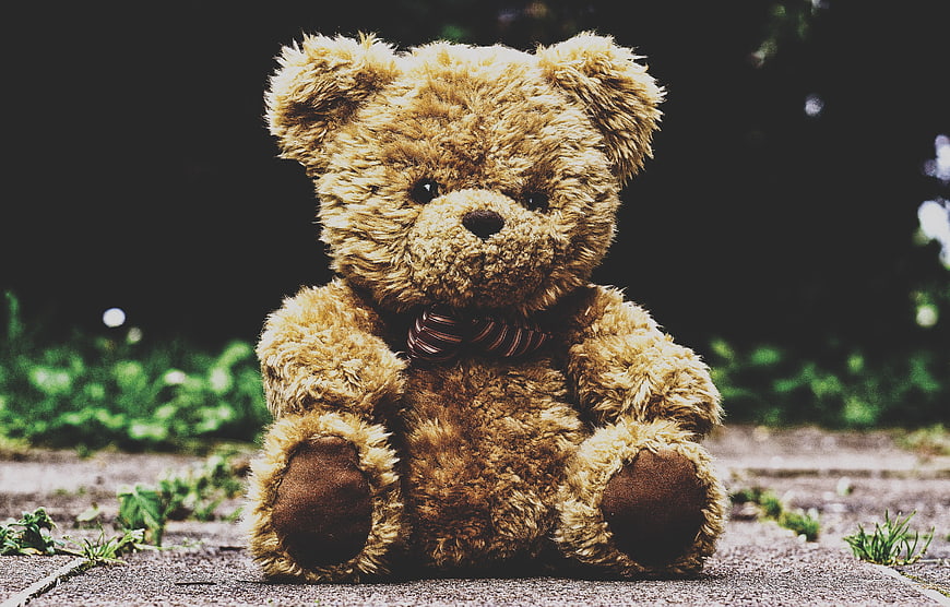Vintage Teddy Bear Sitting On Outdoor Stone Path