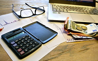 Business Finance Workspace With Calculator, Laptop, And Currency