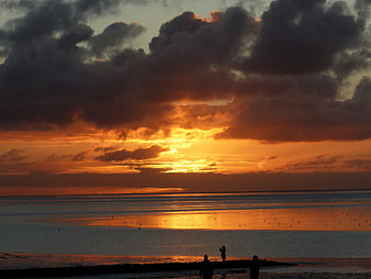 Dramatic Sunset Over Wadden Sea with Silhouetted Figures