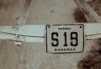 Vintage Nassau Bahamas License Plate on Rusty Metal Frame