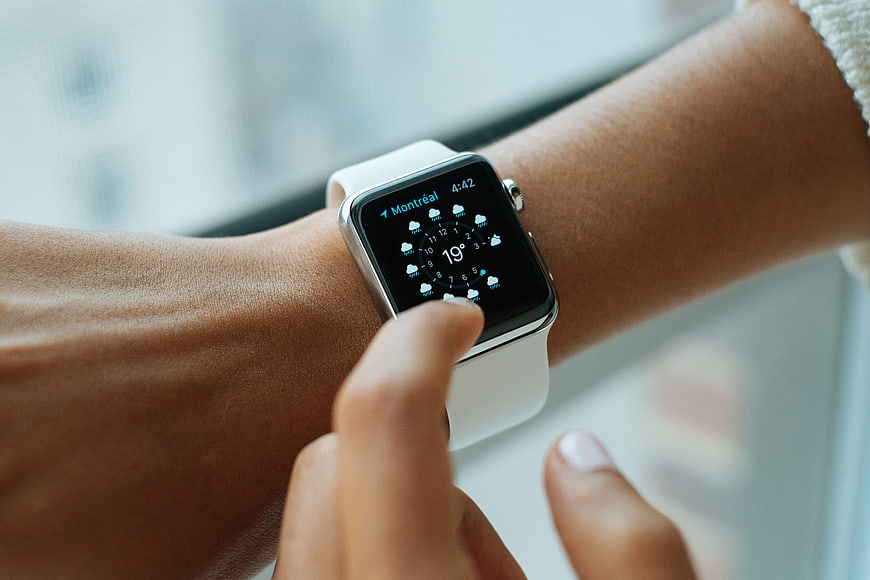 Close-up of person checking weather on smartwatch