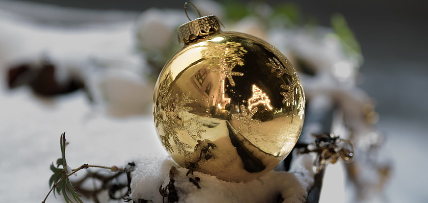 Golden Christmas Ornament in Snow with Reflections