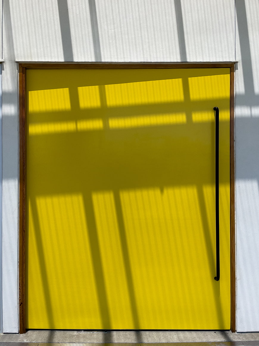 Vibrant Yellow Door with Geometric Shadows