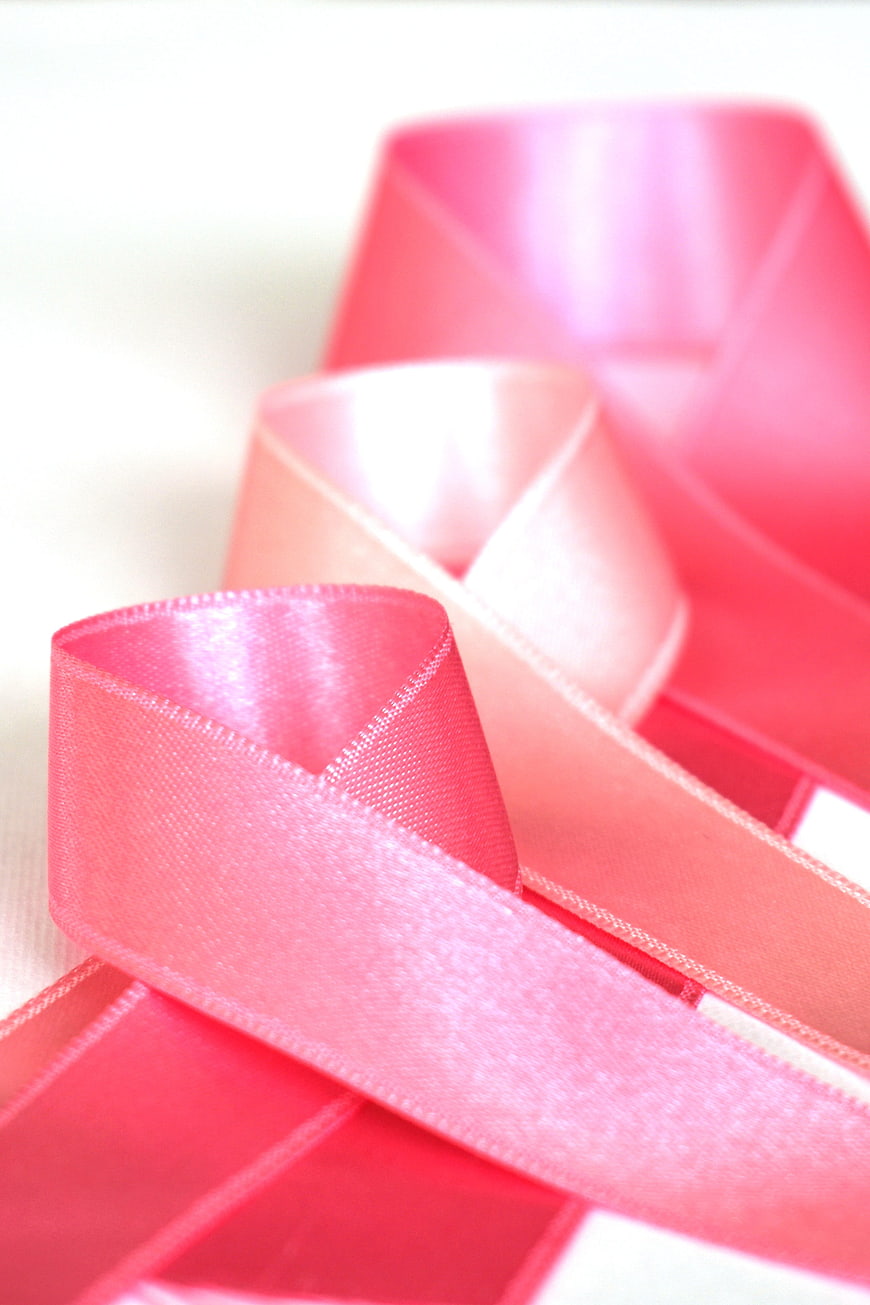 Close-up of a pink satin ribbon on a white background