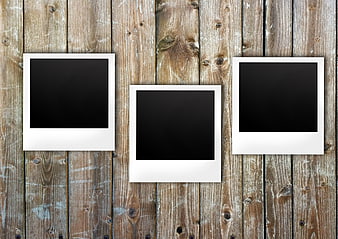 Three blank polaroid frames on rustic wooden background