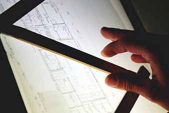 Architect hand measuring blueprint on light table