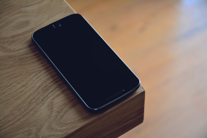 Black Smartphone on Wooden Table with Copyspace