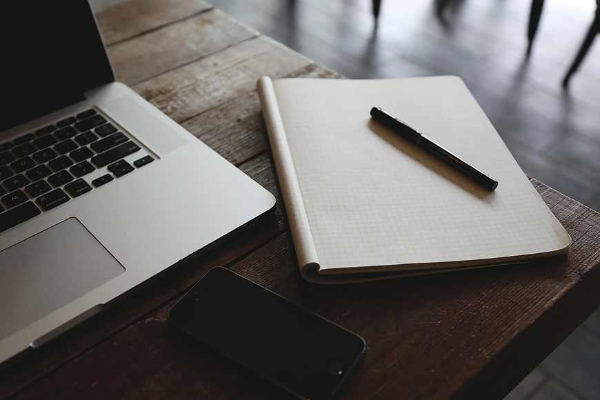 Laptop, Notebook, and Smartphone on Wooden Desk