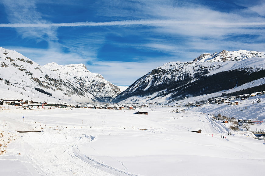 Snowy Alpine Village Landscape with Blue Sky and Mountains