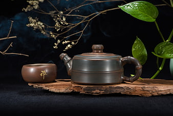 Ceramic Teapot and Cup on Wood with Smoke and Green Leaves
