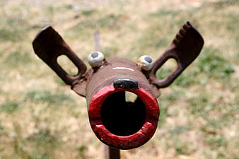 Rusty Metal Pipe Sculpture With Cartoon Eyes And Red Rim