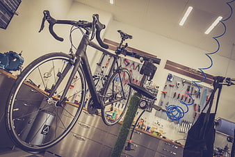 Black Road Bicycle Mounted On Repair Stand In Workshop