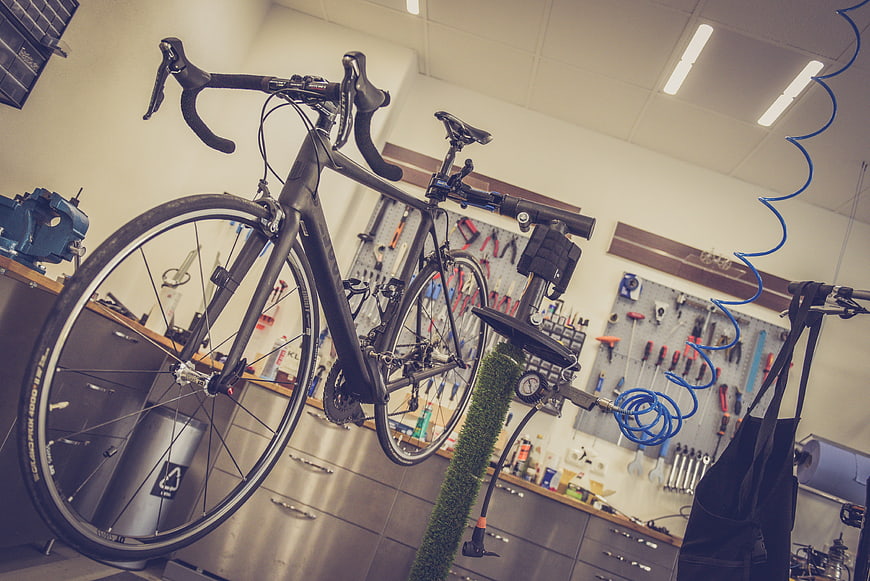 Black Road Bicycle Mounted On Repair Stand In Workshop