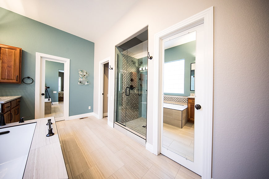 Modern bathroom interior with glass shower and light wood floors