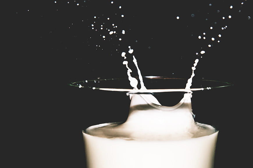 Dynamic Milk Splash in Glass Against Dark Background
