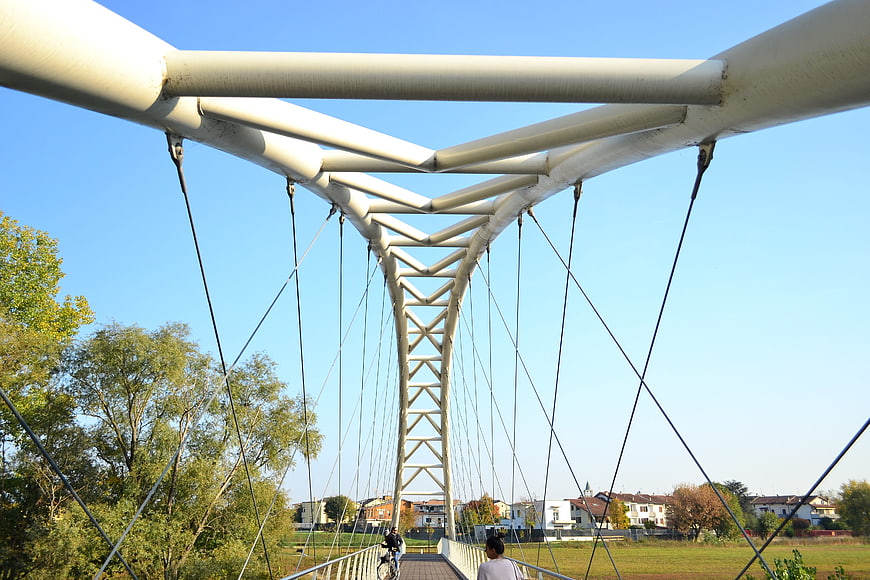Modern white suspension bridge with cyclist and pedestrian