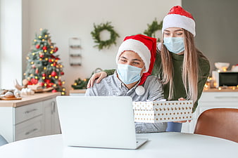 Couple in Santa Hats and Face Masks Video Calling with Gift