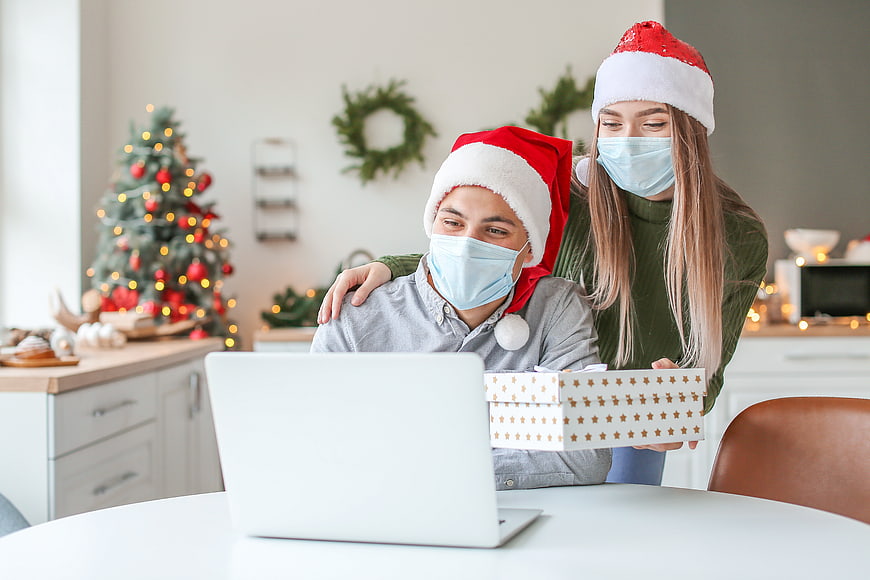 Couple in Santa Hats and Face Masks Video Calling with Gift