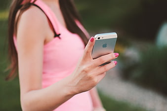 Woman in Pink Top Using Smartphone Outdoors