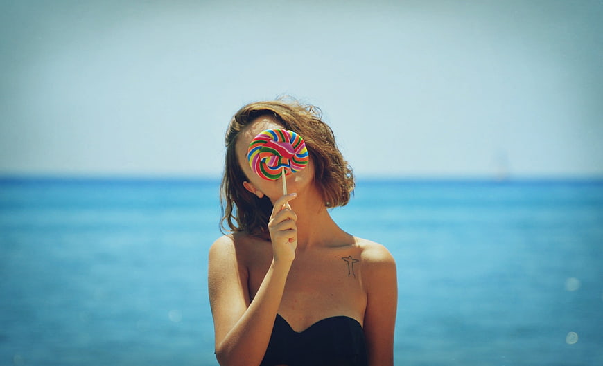 Woman with Rainbow Lollipop on Beach
