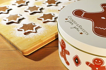 Gingerbread cookies on wooden board with gift tin