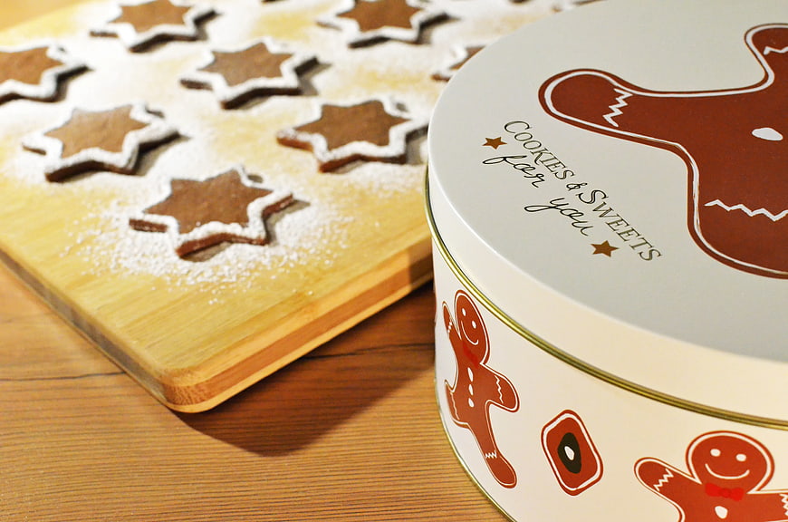 Gingerbread cookies on wooden board with gift tin