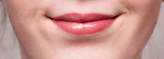 Close-up of glossy pink lips on fair skin