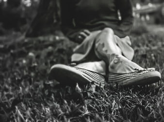 Black and white photo of woman's feet in espadrilles on grass