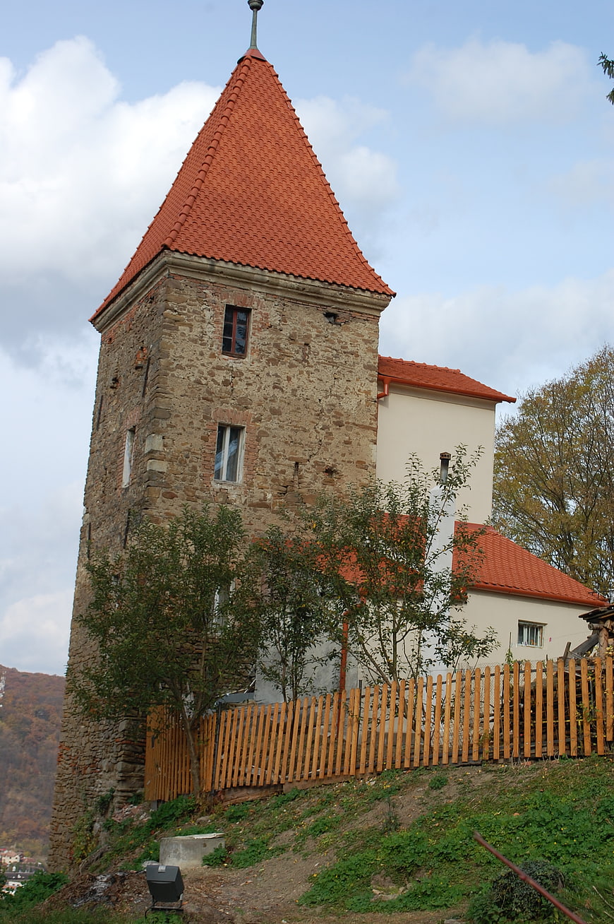 Old Stone Tower with Red Roof and Wooden Fence