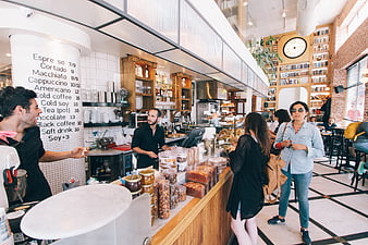 Busy modern cafe interior with customers and baristas