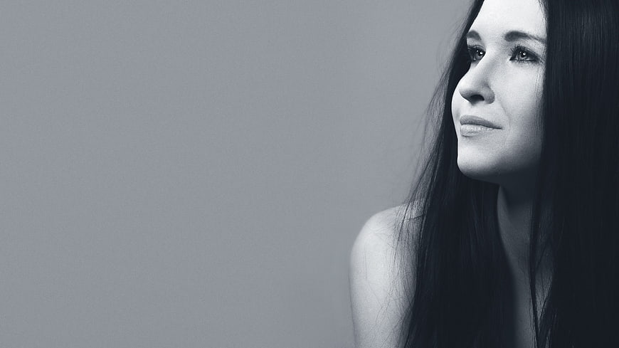 Black and white portrait of a smiling woman with long hair