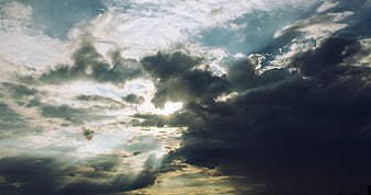 Dramatic Sun Rays Breaking Through Dark Storm Clouds