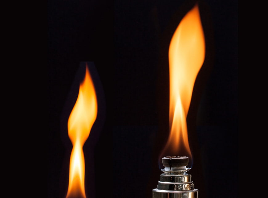 Close-up of a lit lighter flame against a black background