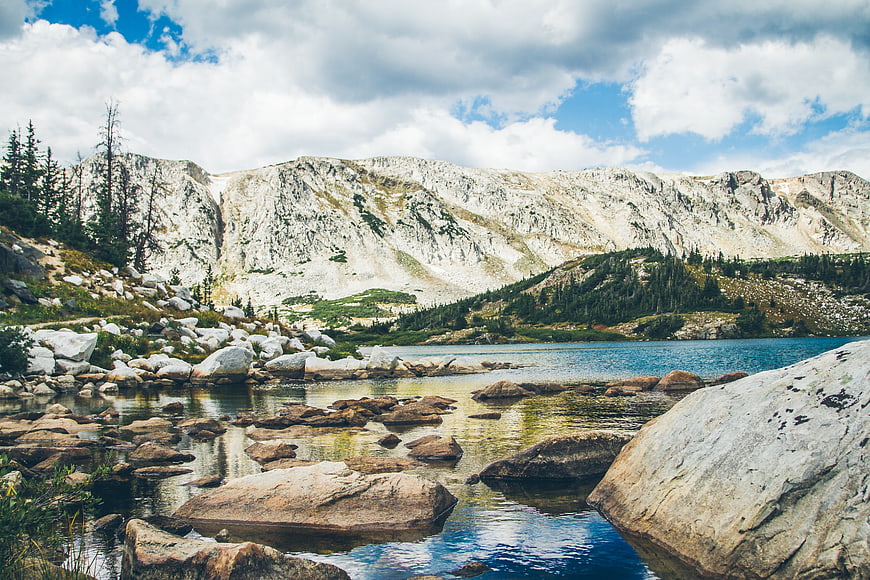 Alpine Lake with Rocky Shore and Mountain Backdrop