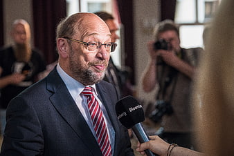 Senior politician in suit being interviewed with microphone