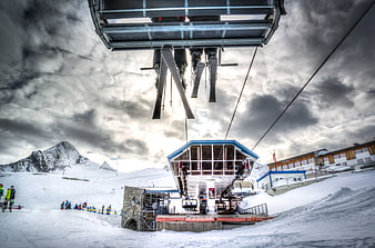 Ski lift station in snowy alps with dramatic sky