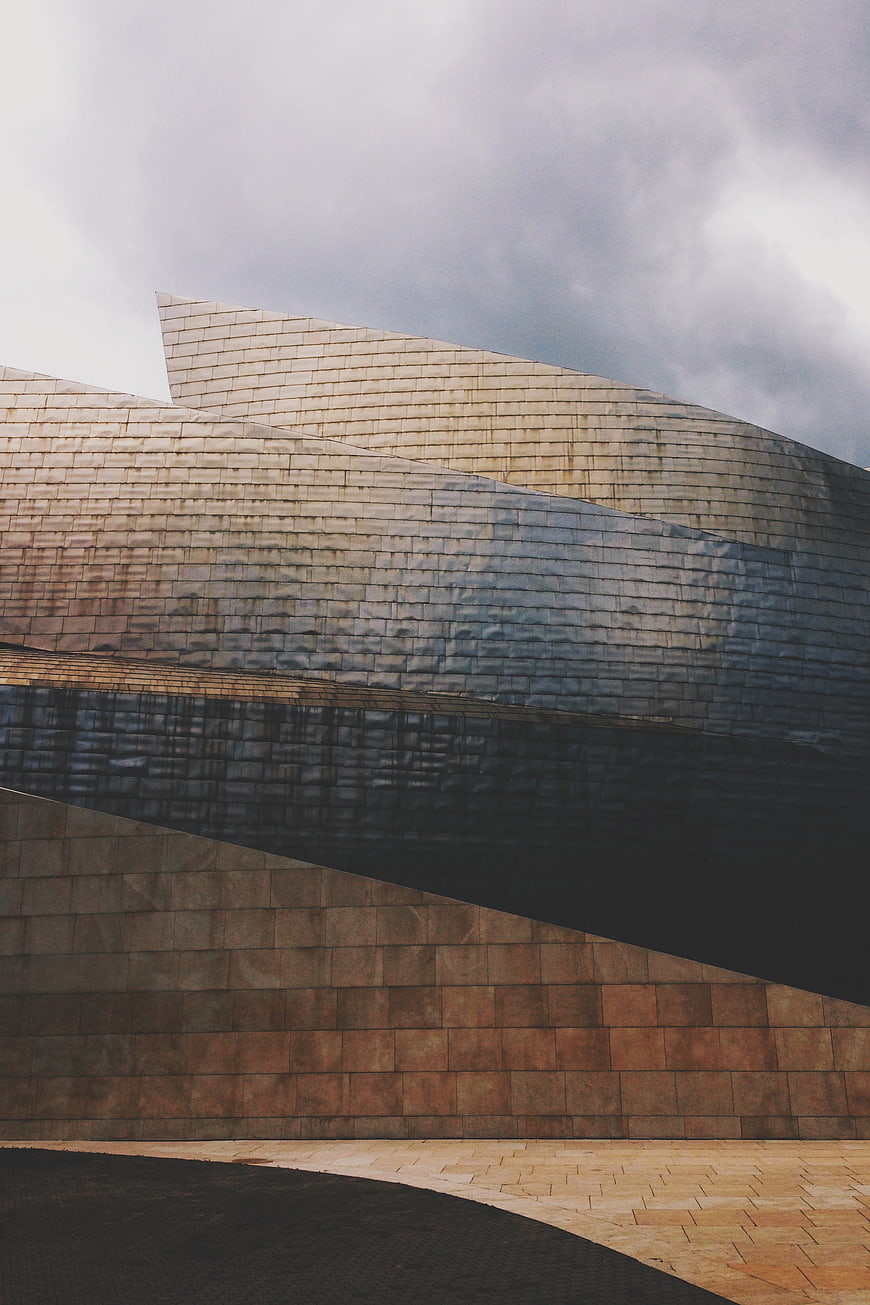 Modern architectural facade with textured stone and dramatic shadows