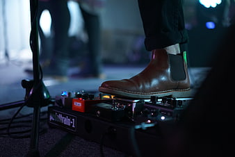 Musician foot on guitar pedalboard stage