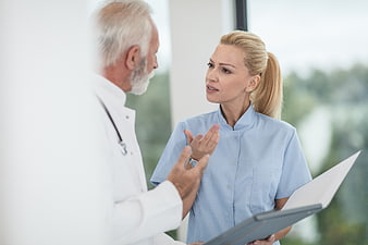 Doctor and nurse discussing patient chart in hospital
