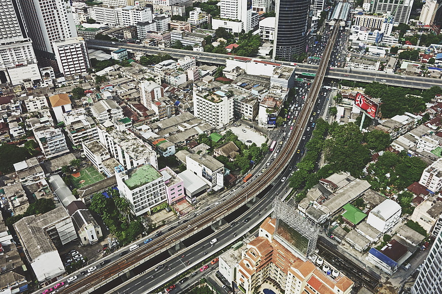 Aerial view of dense urban cityscape with elevated train tracks