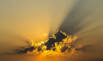Dramatic Golden Sun Rays Bursting Through Dark Clouds at Sunset