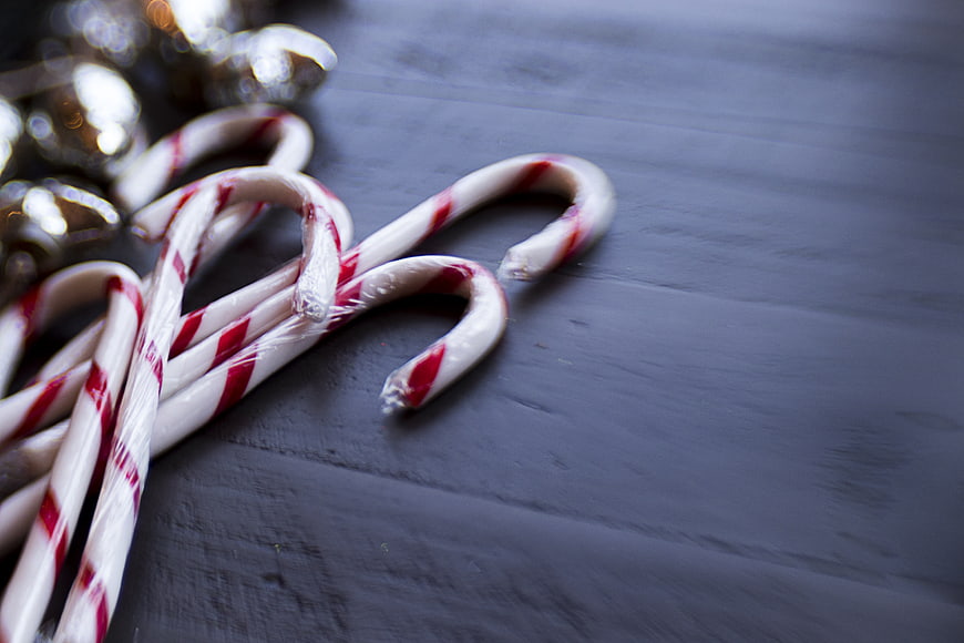 Candy Canes and Silver Bells on Dark Wood Background