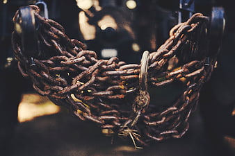 Close-up of rusty metal chains hanging on industrial machinery