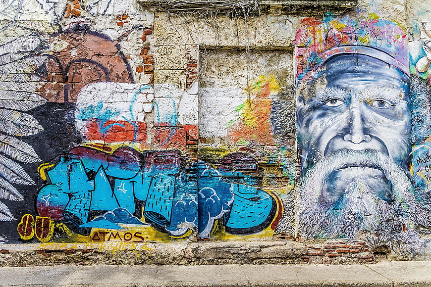 Vibrant Urban Street Art Mural Featuring Man Portrait And Spray Paint Tags