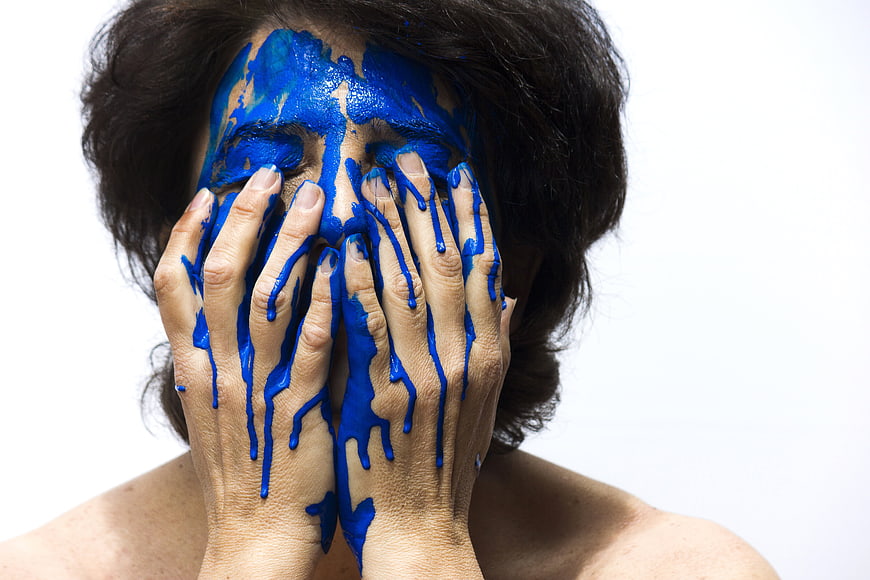 Woman with blue paint on face and hands