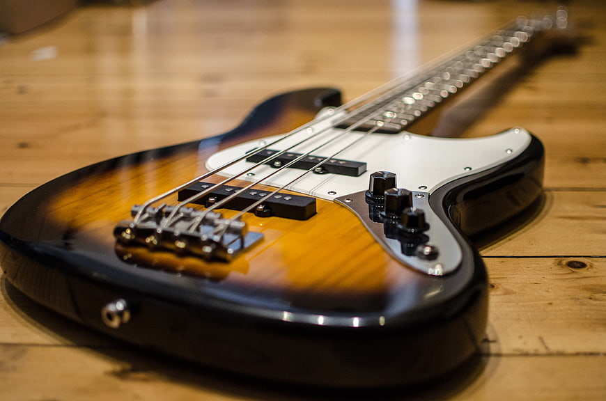 Sunburst electric bass guitar on wooden floor